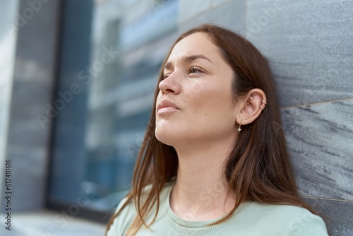 Young beautiful woman looking to the side with serious expression at street