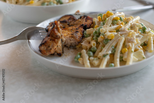 Grilled turkey steak with pasta salad on a plate