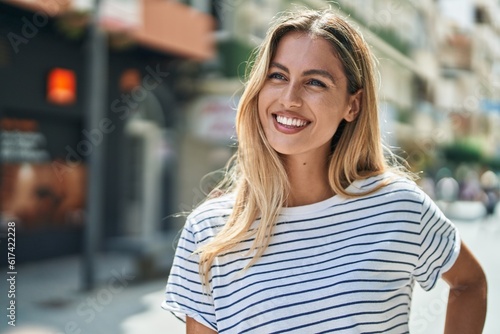 Young blonde woman smiling confident looking to the side at street © Krakenimages.com