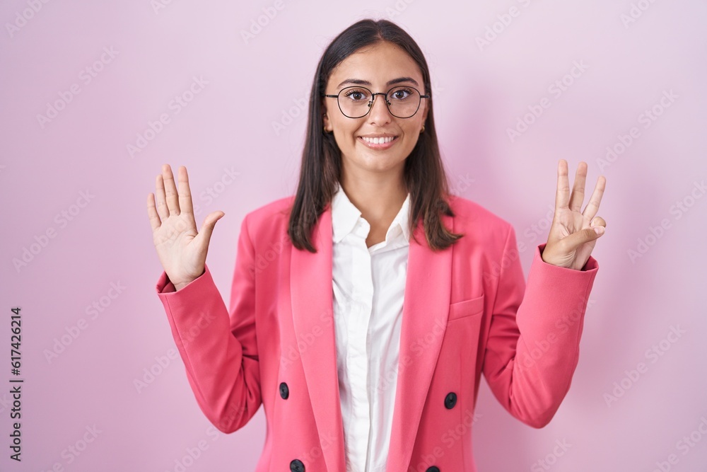 Young hispanic woman wearing business clothes and glasses showing and pointing up with fingers number eight while smiling confident and happy. Young hispanic woman wearing business clothes and glasses showing and pointing up with fingers number eight while smiling confident and happy.