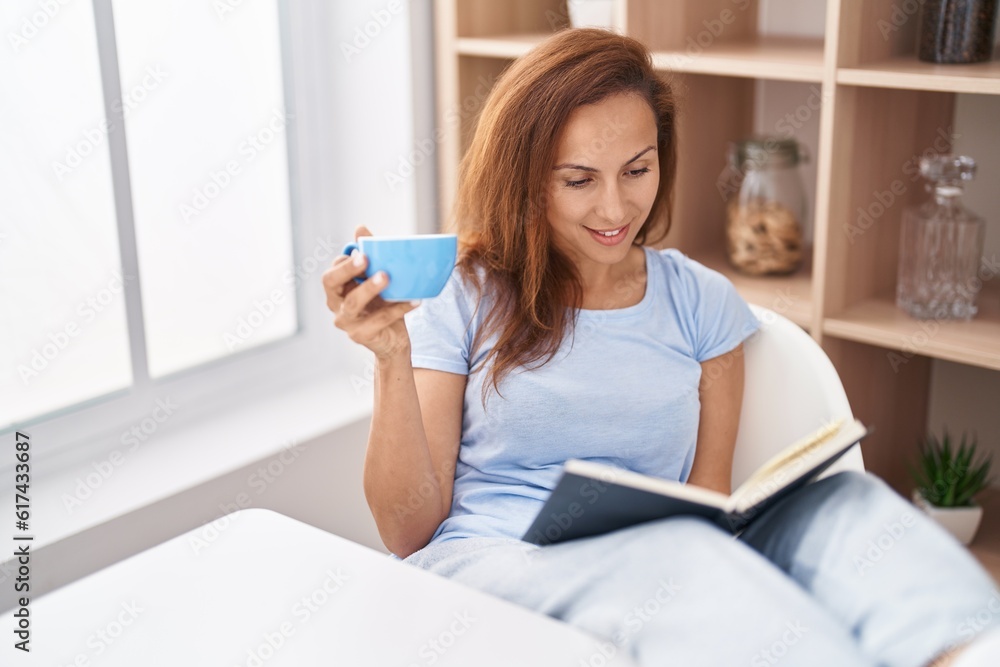 Young woman reading book and drinking coffee at home Young woman reading book and drinking coffee at home