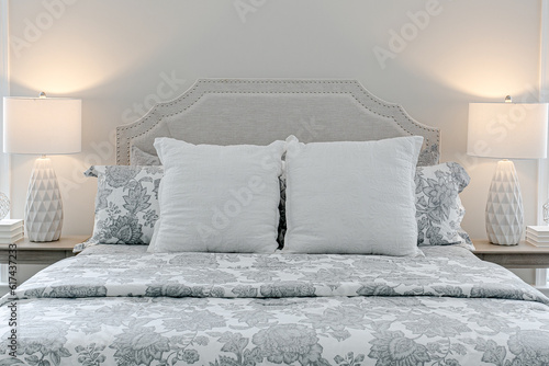 Wallpaper Mural Beautiful neutral calm primary bedroom with large bed with pattern bedding and matching lamps white walls professionally styled Torontodigital.ca