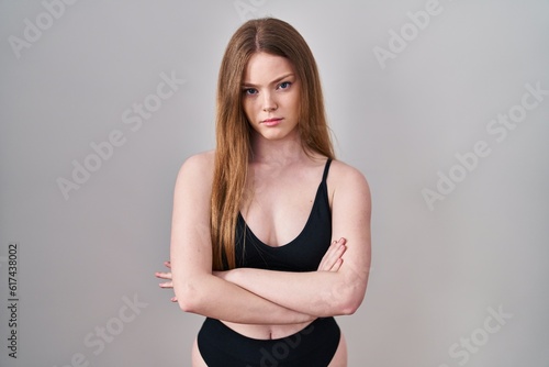 Young caucasian woman wearing lingerie skeptic and nervous, disapproving expression on face with crossed arms. negative person.