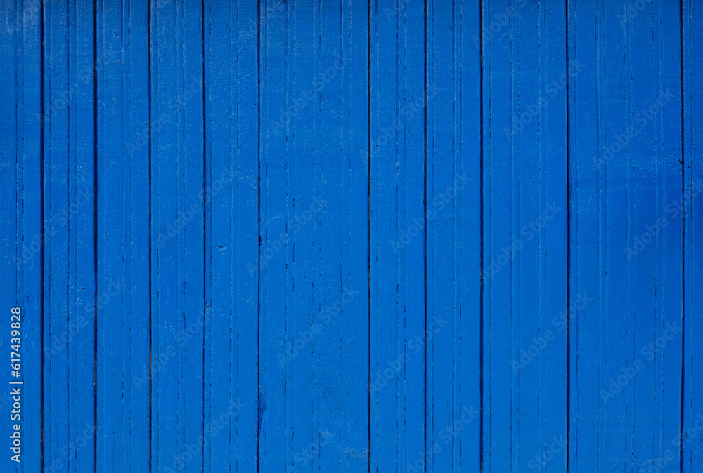 Wooden wall with narrow textured boards with cracks, with thick bright blue paint. Backgrounds and textures Wooden wall with narrow textured boards with cracks, with thick bright blue paint. Backgrounds and textures