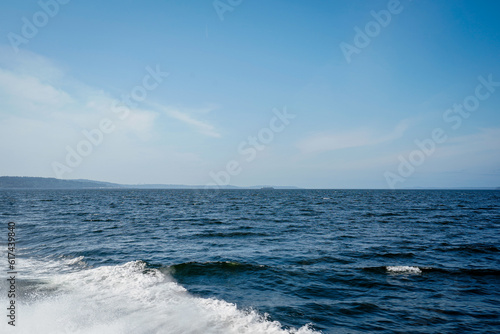 Ocean view from a boat at Puget Sound, state of Washington, USA. Scenic view of water, mountains, beach.