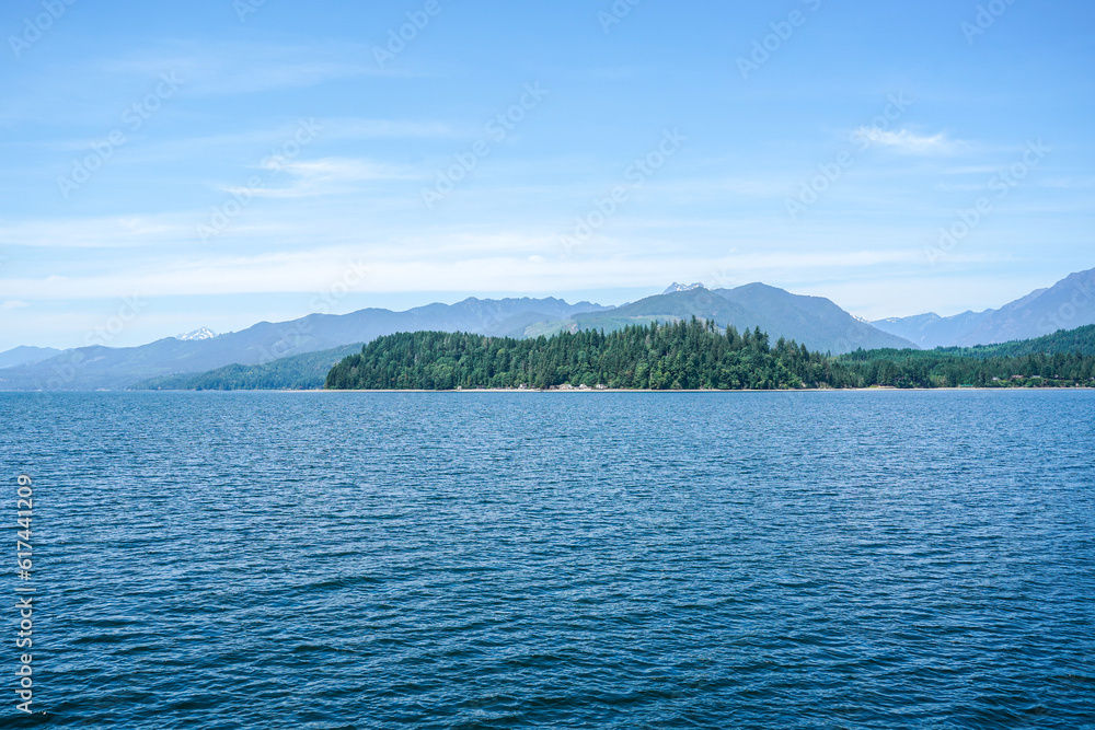 Ocean view from a boat at Puget Sound, state of Washington, USA. Scenic view of water, mountains, beach.
