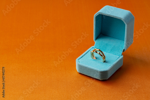 Golden ring in jewelry box on orange background © fotofabrika