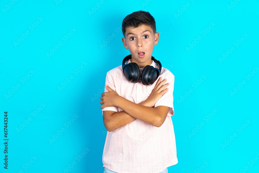 Shocked embarrassed Little hispanic boy wearing white shirt keeps mouth widely opened. Hears unbelievable novelty stares in stupor Shocked embarrassed Little hispanic boy wearing white shirt keeps mouth widely opened. Hears unbelievable novelty stares in stupor