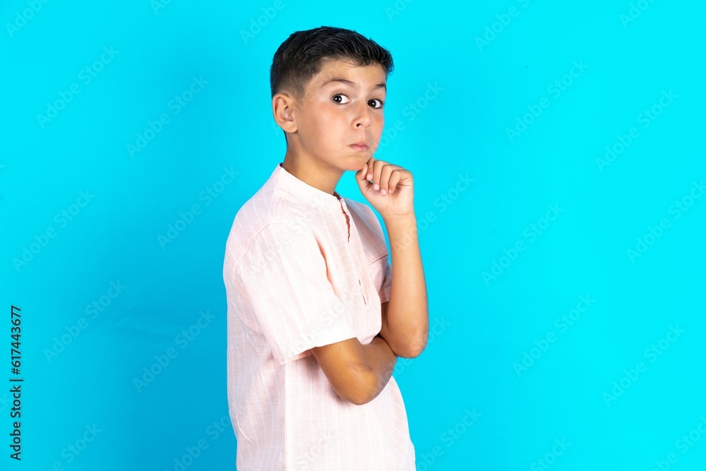 Astonished Little hispanic boy wearing white shirt looks aside surprisingly with opened mouth. Astonished Little hispanic boy wearing white shirt looks aside surprisingly with opened mouth.