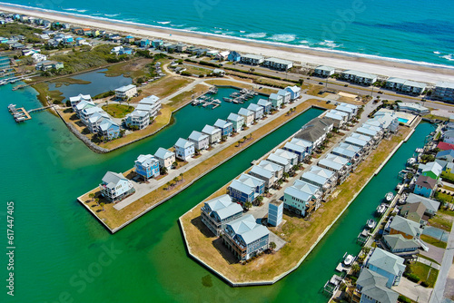 Aerial view of beach houses lined up along the canals of the intracoastal waterway with the Atlantic Ocean in the distance. 