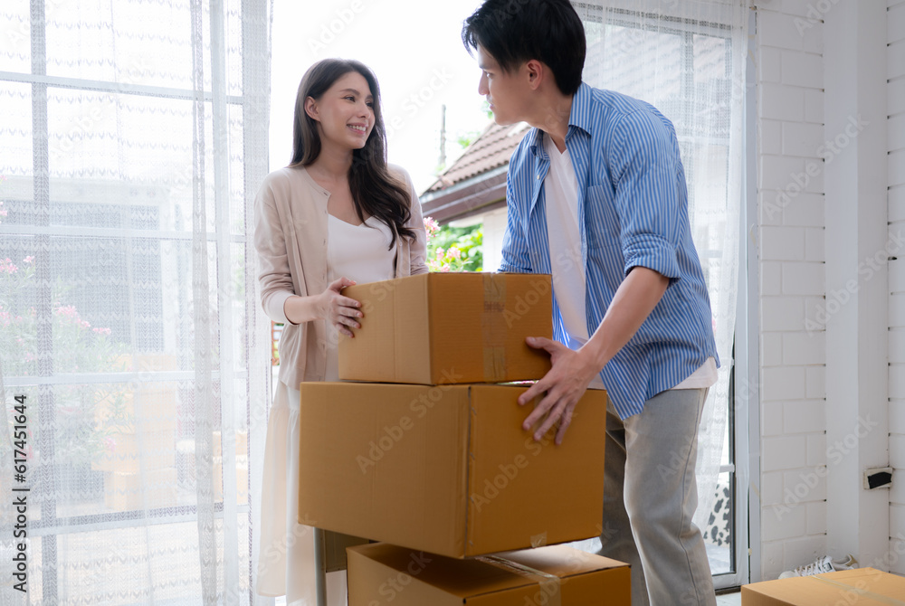 Young asian couple moving in new house. Asian man and woman holding boxes. Young asian couple moving in new house. Asian man and woman holding boxes.
