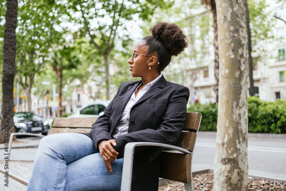 Pensive African American lady resting on street bench Pensive African American lady resting on street bench