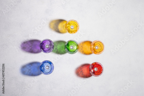 Colorful goblets and their falling shadows on a white background