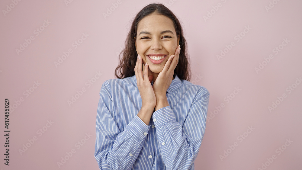 Young beautiful hispanic woman touching face with hands over isolated pink background Young beautiful hispanic woman touching face with hands over isolated pink background