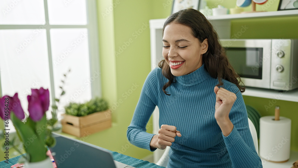 Young beautiful hispanic woman using laptop dancing at home Young beautiful hispanic woman using laptop dancing at home