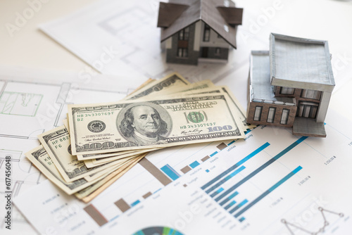 paper house model on background of US dollars banknotes. Housing market, purchase or rental of real estate