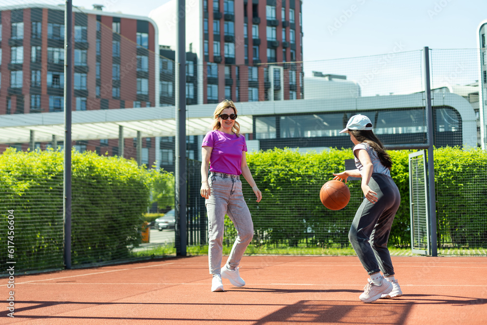 Obraz premium Mother and daughter playing basketball