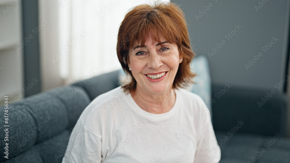 Middle age woman smiling confident sitting on sofa home Middle age woman smiling confident sitting on sofa home