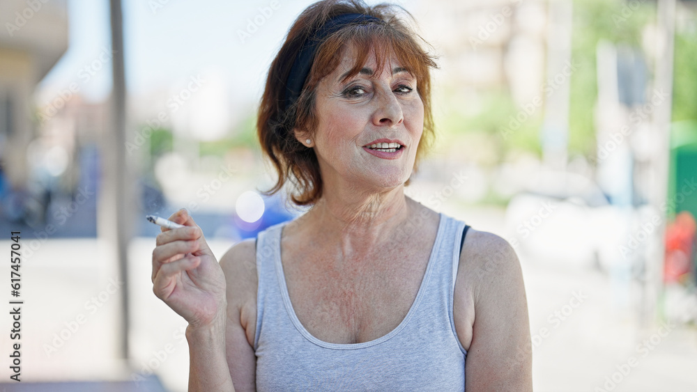Middle age woman smoking and speaking at street