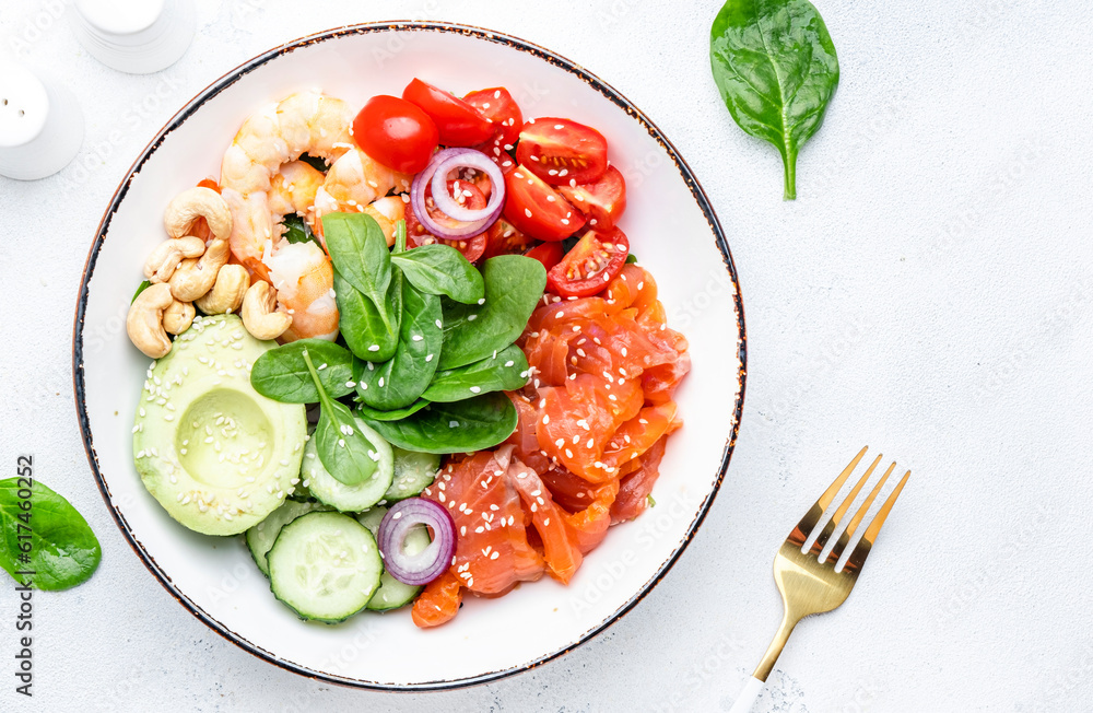 Keto salad with spinach, salmon, shrimp, avocado, cucumber, tomato, nuts, sesame seeds. Low-carbohydrate lunch rich in healthy fats. White table background, top view Keto salad with spinach, salmon, shrimp, avocado, cucumber, tomato, nuts, sesame seeds. Low-carbohydrate lunch rich in healthy fats. White table background, top view