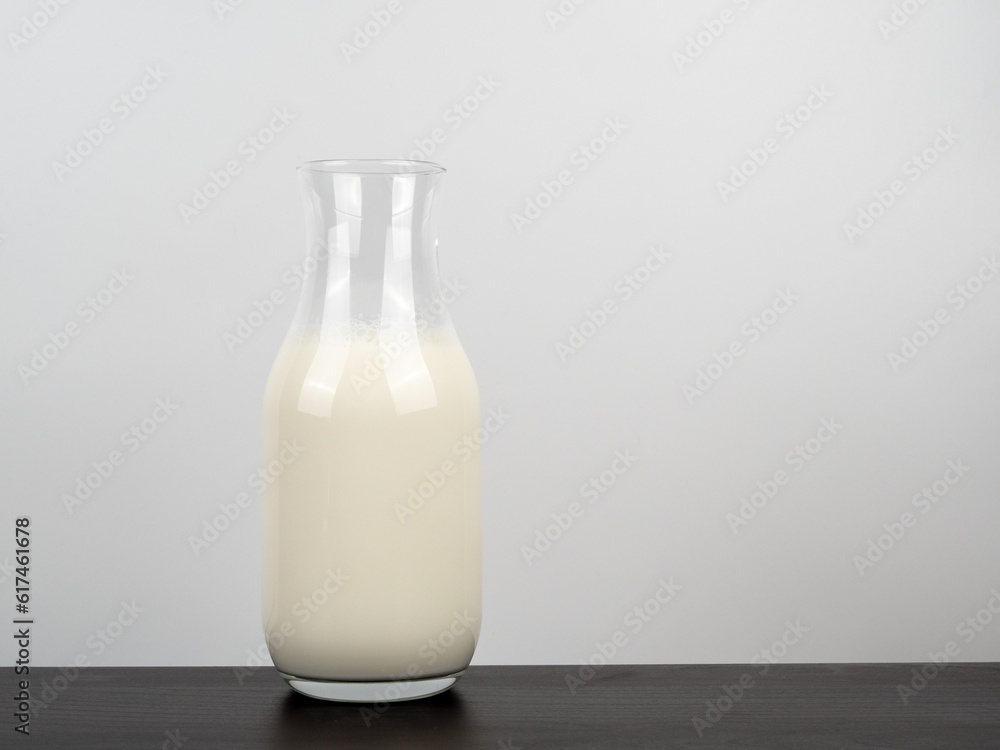 A bottle of milk on a wooden table. A bottle of milk on a light background. A bottle of milk on a wooden table. A bottle of milk on a light background.