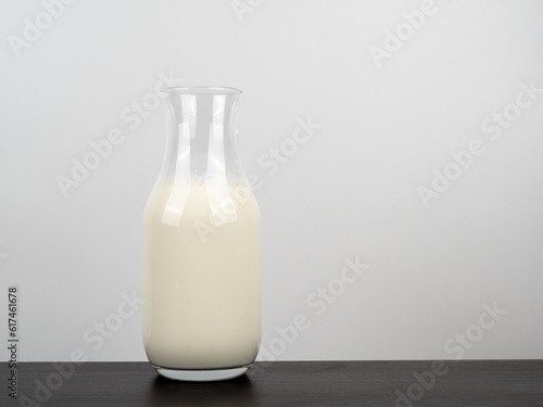 A bottle of milk on a wooden table. A bottle of milk on a light background.