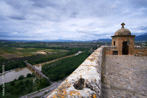 San Vicente de la Sonsierra, Spain; June 21, 2023: Panoramic from the castle of San Vicente de la Sonsierra of the Ebro river, medieval bridge and vineyards in La Rioja photo