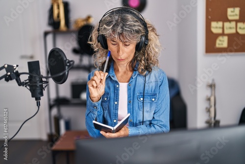 Φωτογραφία Middle age woman singer composing song at music studio