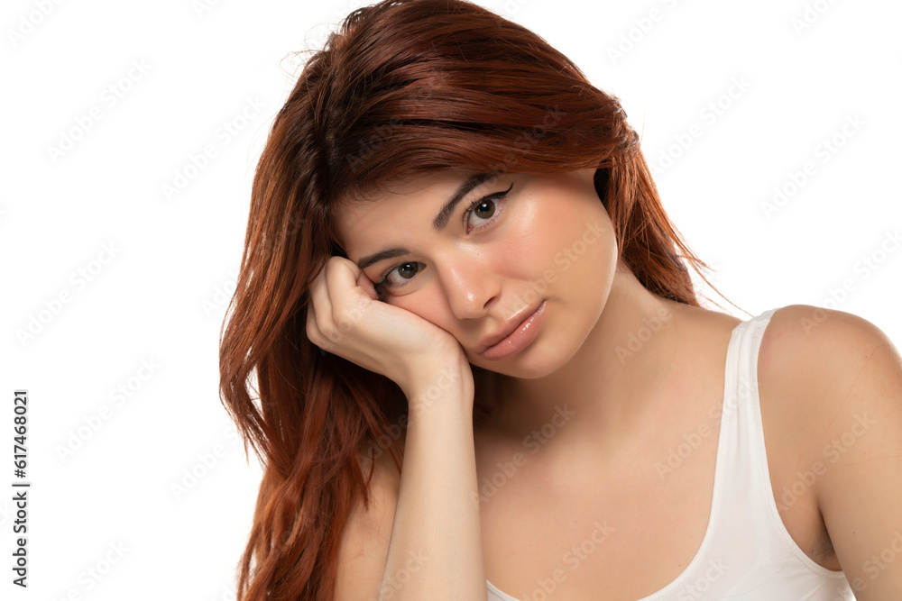 Portrait of sad redhead young woman on a white background Portrait of sad redhead young woman on a white background