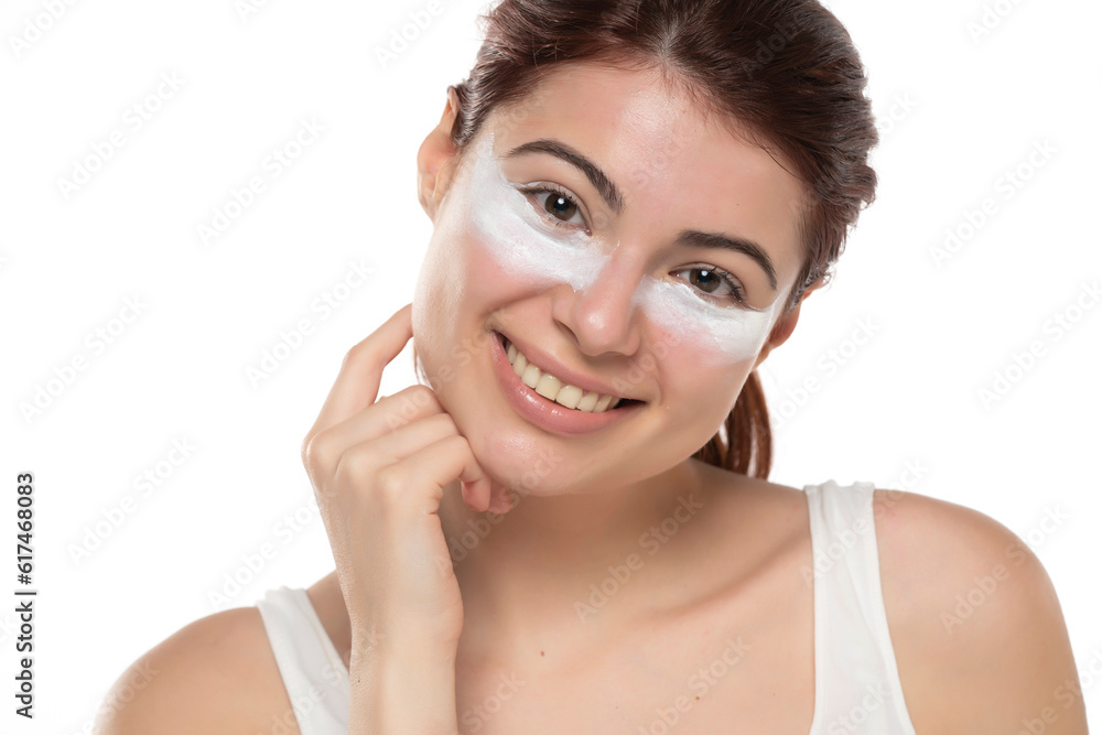 Portrait of adorable, stylish redhead with cream under eyes, botox effect, fighting with dark circles, looking at camera isolated on white background Portrait of adorable, stylish redhead with cream under eyes, botox effect, fighting with dark circles, looking at camera isolated on white background