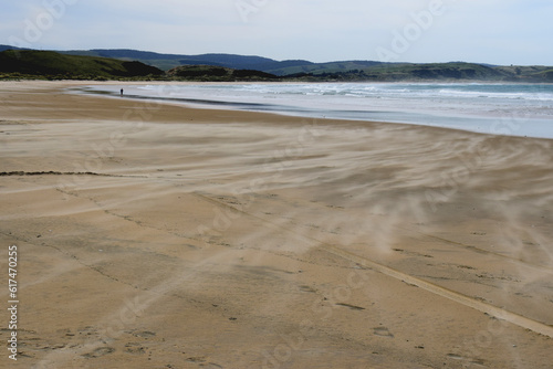 Lonely walker on windblown deserted beach, Catlins, South Island, New Zealand  photo