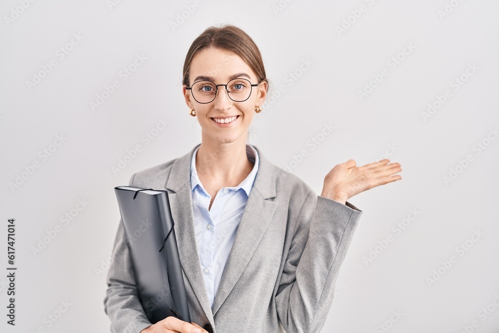 Young caucasian woman wearing business clothes and glasses smiling cheerful presenting and pointing with palm of hand looking at the camera. Young caucasian woman wearing business clothes and glasses smiling cheerful presenting and pointing with palm of hand looking at the camera.