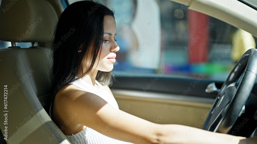 Young beautiful hispanic woman driving car with relaxed face at street Young beautiful hispanic woman driving car with relaxed face at street