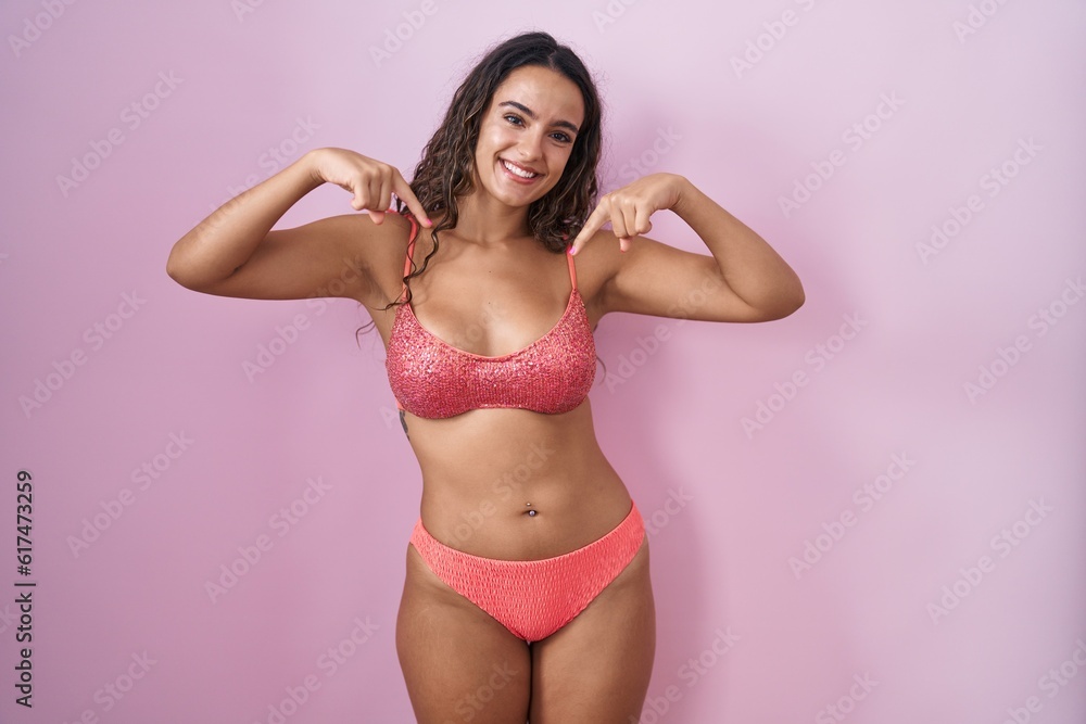 Young hispanic woman wearing lingerie over pink background looking confident with smile on face, pointing oneself with fingers proud and happy. Young hispanic woman wearing lingerie over pink background looking confident with smile on face, pointing oneself with fingers proud and happy.