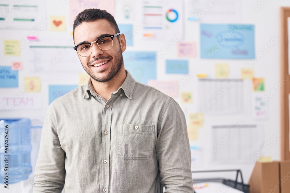 Fototapeta premium Young hispanic man business worker smiling confident at office