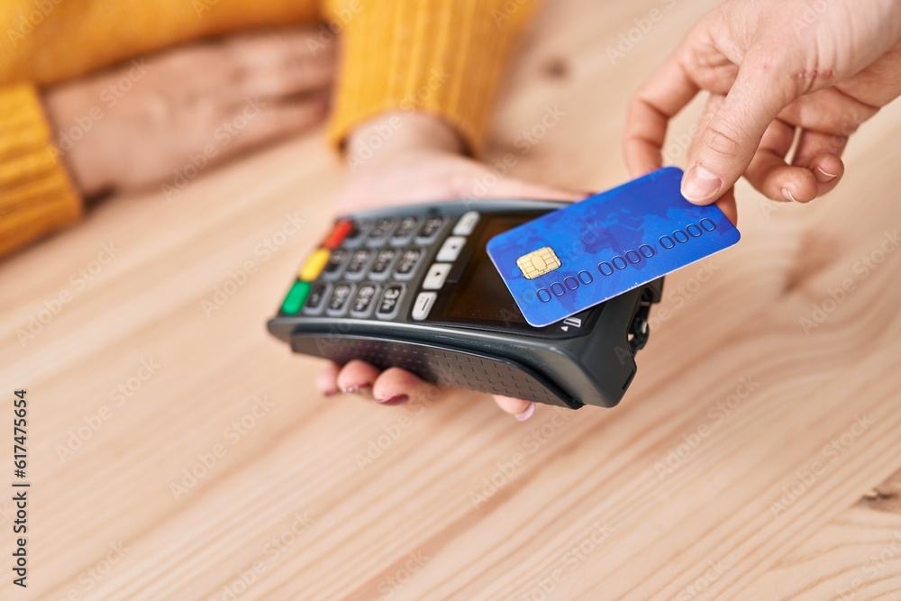 Middle age blonde woman ecommerce business worker using credit card and data phone at office