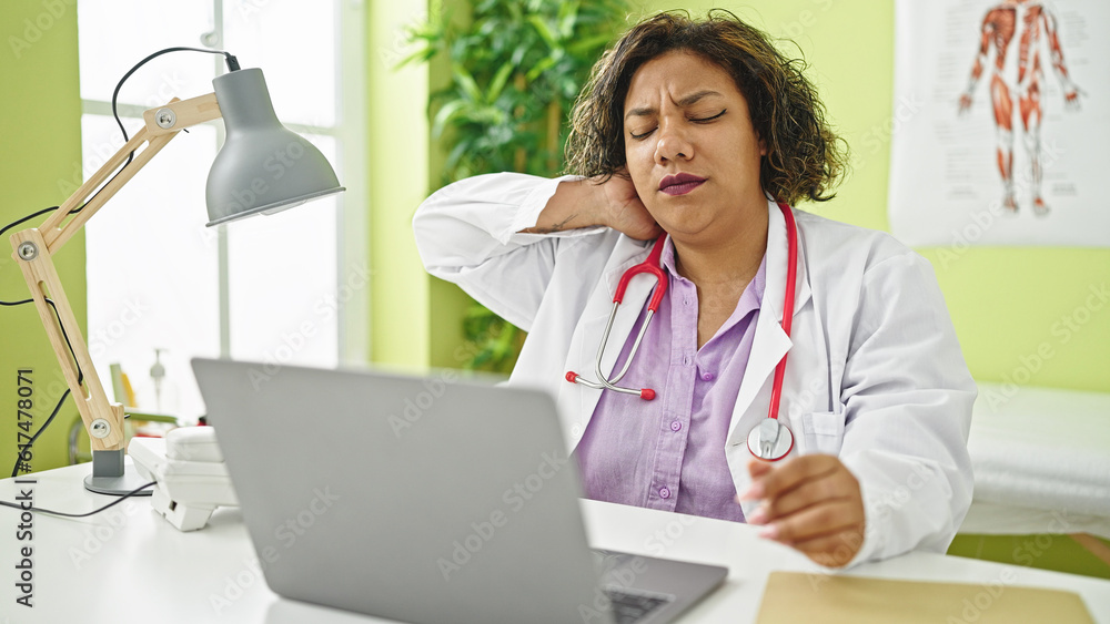 Young beautiful latin woman doctor stressed working suffering for cervical pain at clinic Young beautiful latin woman doctor stressed working suffering for cervical pain at clinic