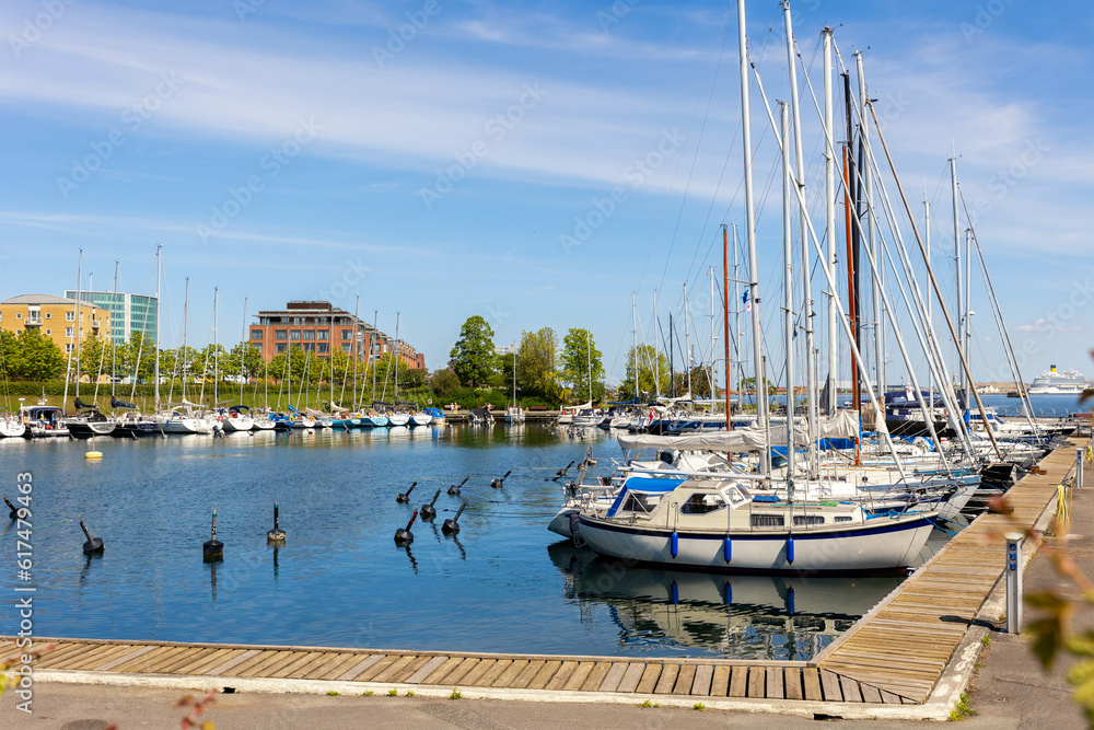 Scenic view of Copenhagen port Langelinie marina with many moored docking yachrs and sailboats and cruise ship blue sky background. Danmark capital city harbour cityscape view