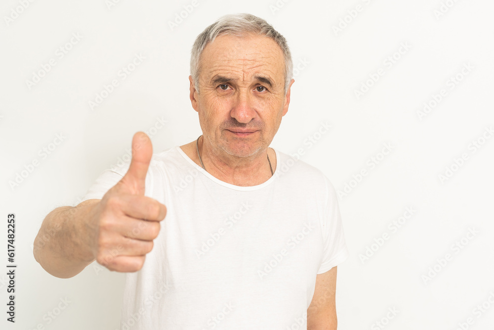 Elderly Caucasian man with white hair smiling on gray background. Elderly Caucasian man with white hair smiling on gray background.