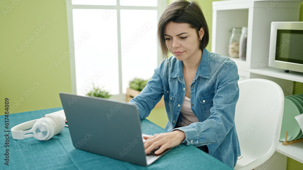 Young caucasian woman using laptop sitting on the table at home Young caucasian woman using laptop sitting on the table at home