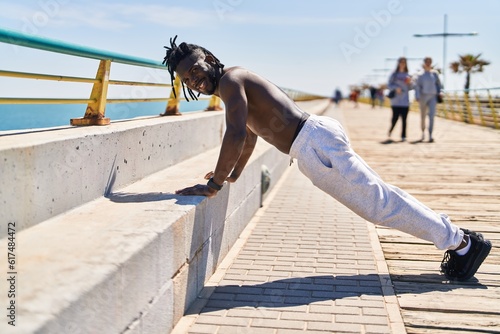 African american woman shirtless training push up at seaside