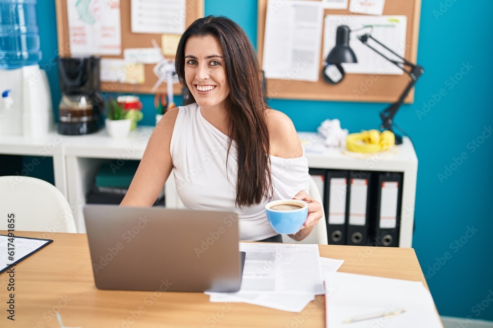 Young beautiful hispanic woman business worker using laptop drinking coffee at office Young beautiful hispanic woman business worker using laptop drinking coffee at office