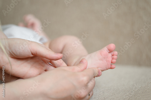 Mom massages the baby legs. Children massage.The concept of babysitting,maternity leave,masseur.Prevention of flat feet
