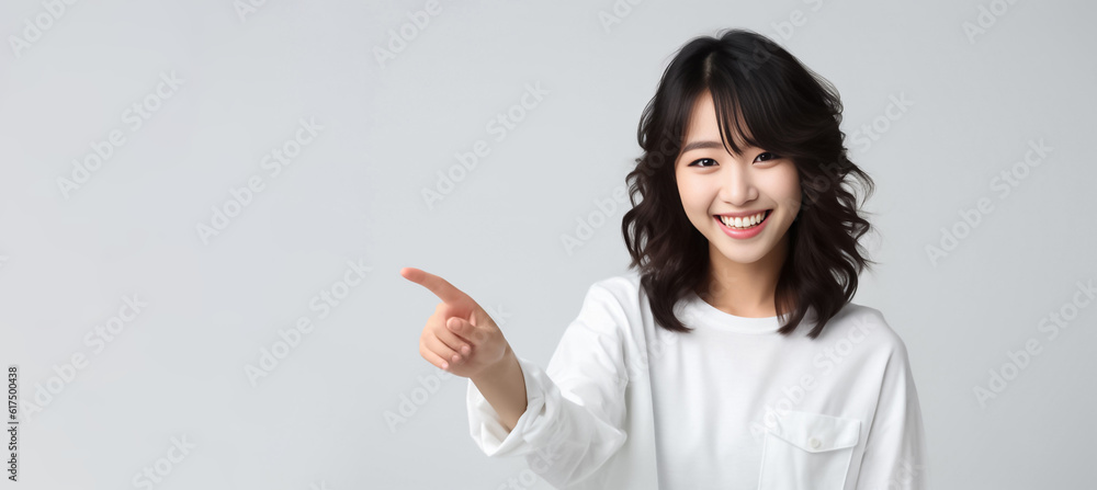 Pointing finger of an Asian girl highlights vacant space on a white background, making it a prime choice for a promotional advertising banner. Generative AI. Pointing finger of an Asian girl highlights vacant space on a white background, making it a prime choice for a promotional advertising banner. Generative AI.