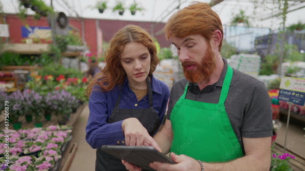 Male Staff Sharing Inventory Data on Tablet with Female Colleague in Flower Shop. Two Employees Engaging in Retail Tech Interaction. Local Business Concept Male Staff Sharing Inventory Data on Tablet with Female Colleague in Flower Shop. Two Employees Engaging in Retail Tech Interaction. Local Business Concept