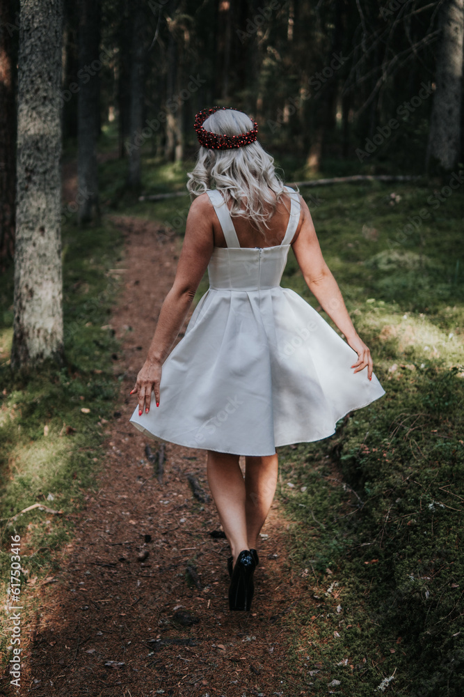 Happy Woman Walking in Green Forest, Wearing Fashionable Dress Happy Woman Walking in Green Forest, Wearing Fashionable Dress