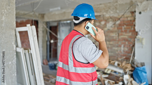  builder talking on smartphone at construction site