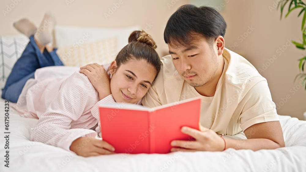 Man and woman couple lying on bed reading book at bedroom Man and woman couple lying on bed reading book at bedroom