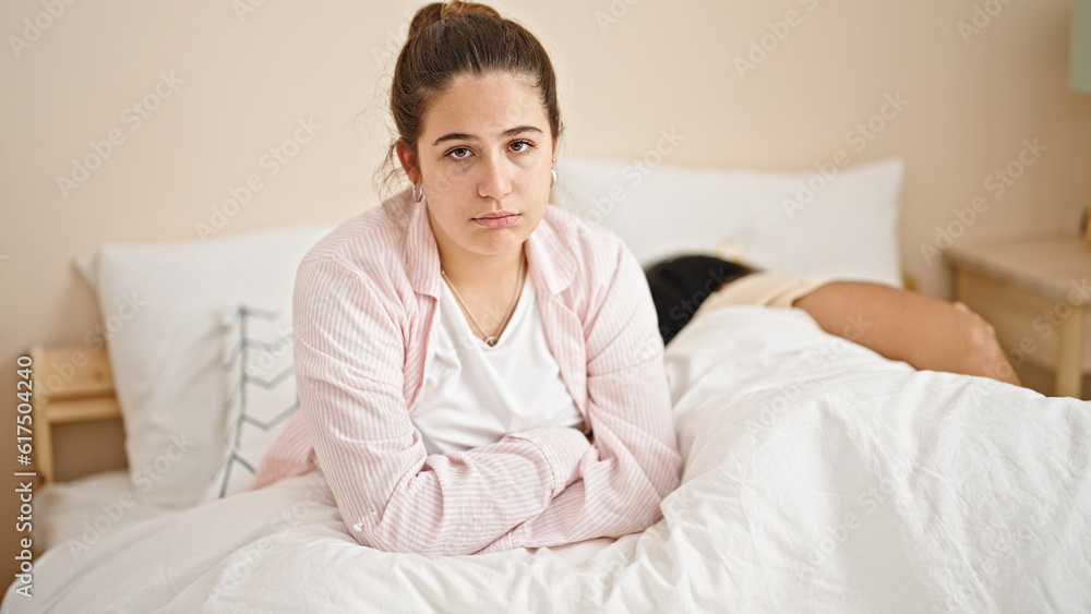 Man and woman sitting on bed looking upset at bedroom Man and woman sitting on bed looking upset at bedroom