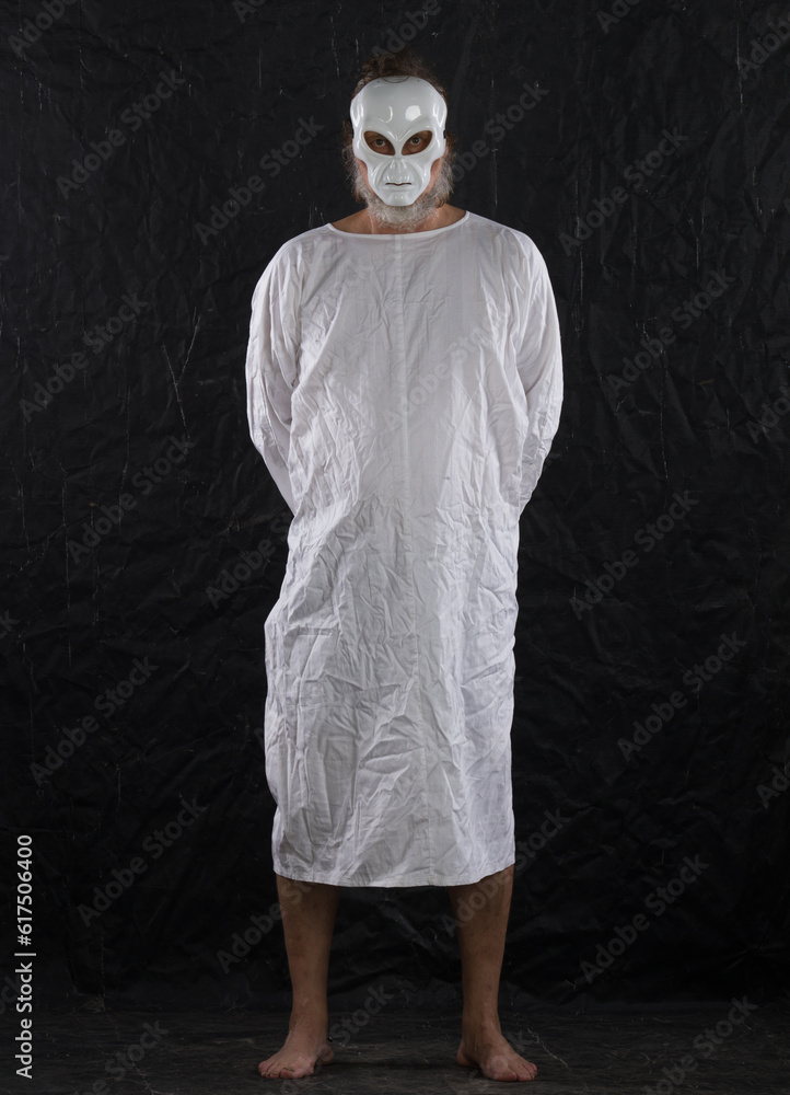 man in an alien mask in white on a black background man in an alien mask in white on a black background